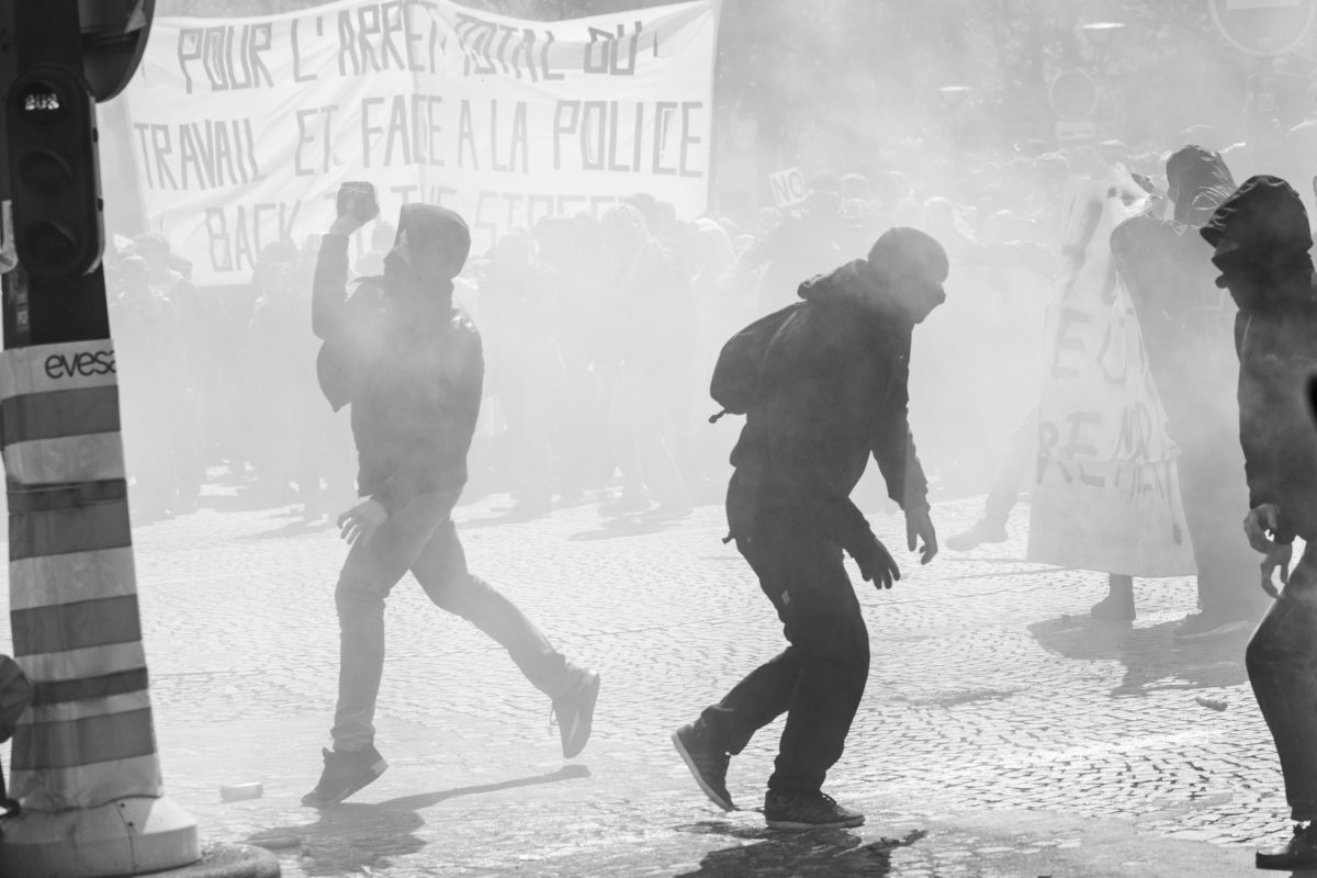 Protester throwing a stone surrounded by tear gas | © Christian Martischius