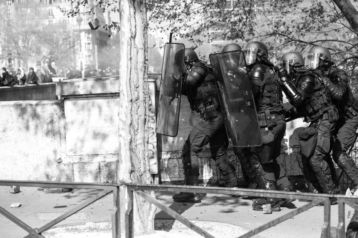 Riot police hiding behind their shields to fend of a stone | © Christian Martischius