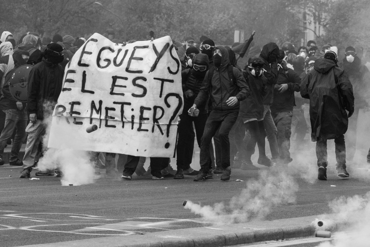 Protesters holding a banner surrounded by tear gas grenades | © Christian Martischius